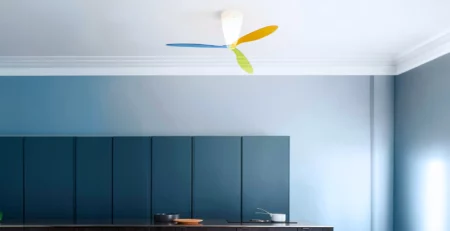 Luceplan Blow, ventilatore da soffitto con luce progettato da Ferdi Giardini, installato in un soggiorno con travi a vista. Una sospensione che integra illuminazione e movimentazione dell’aria nello stesso progetto.