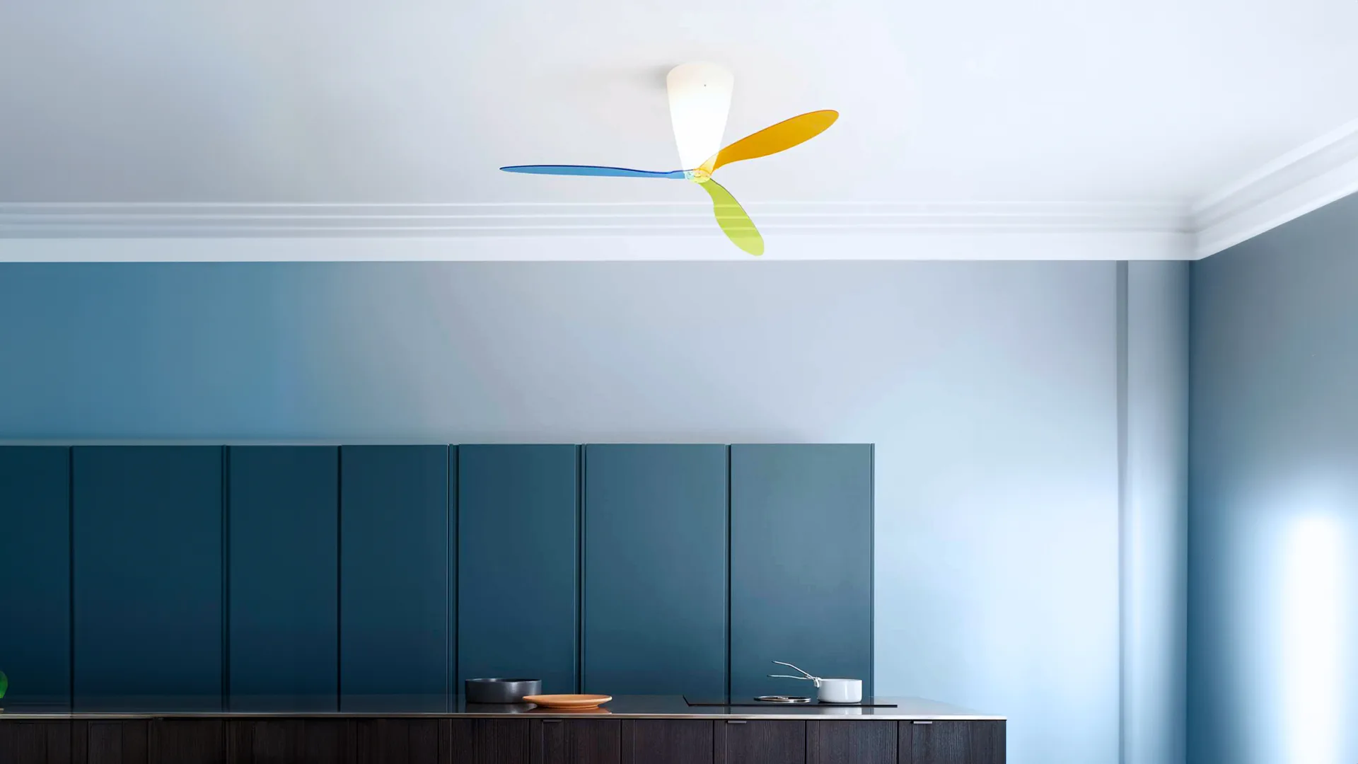 Luceplan Blow, ventilatore da soffitto con luce progettato da Ferdi Giardini, installato in un soggiorno con travi a vista. Una sospensione che integra illuminazione e movimentazione dell’aria nello stesso progetto.