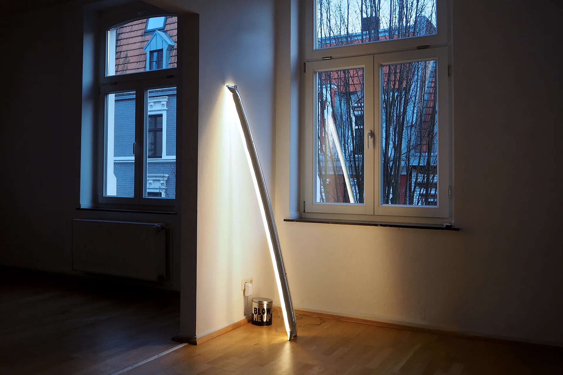 Lampada gonfiabile Blow Me Up di Ingo Maurer appoggiata a parete e accesa in un interno