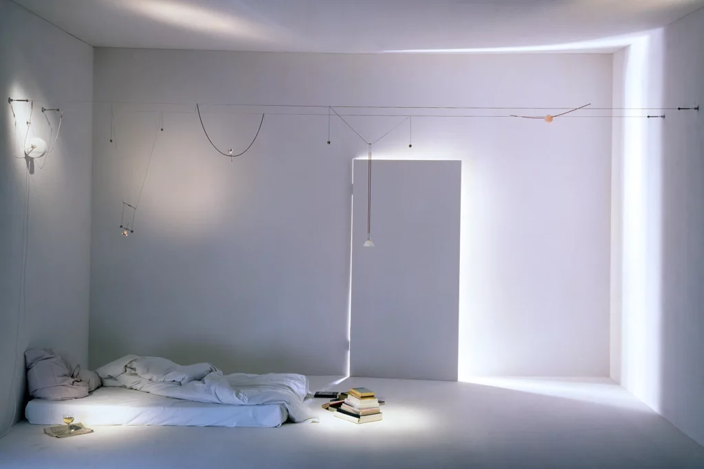 Sistema di illuminazione a cavi YaYaHo di Ingo Maurer installato in una camera da letto