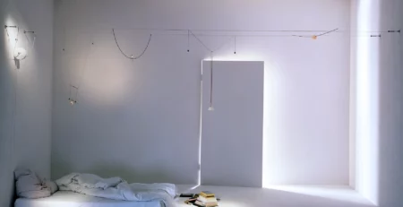Sistema di illuminazione a cavi YaYaHo di Ingo Maurer installato in una camera da letto
